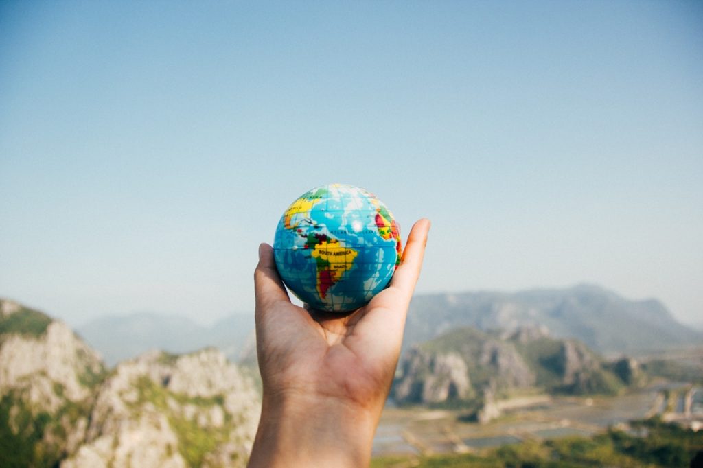 Hand holding a toy in a shape of a planet Earth