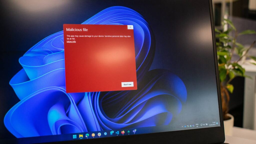 An antivirus program shows a malicious file on a laptop screen