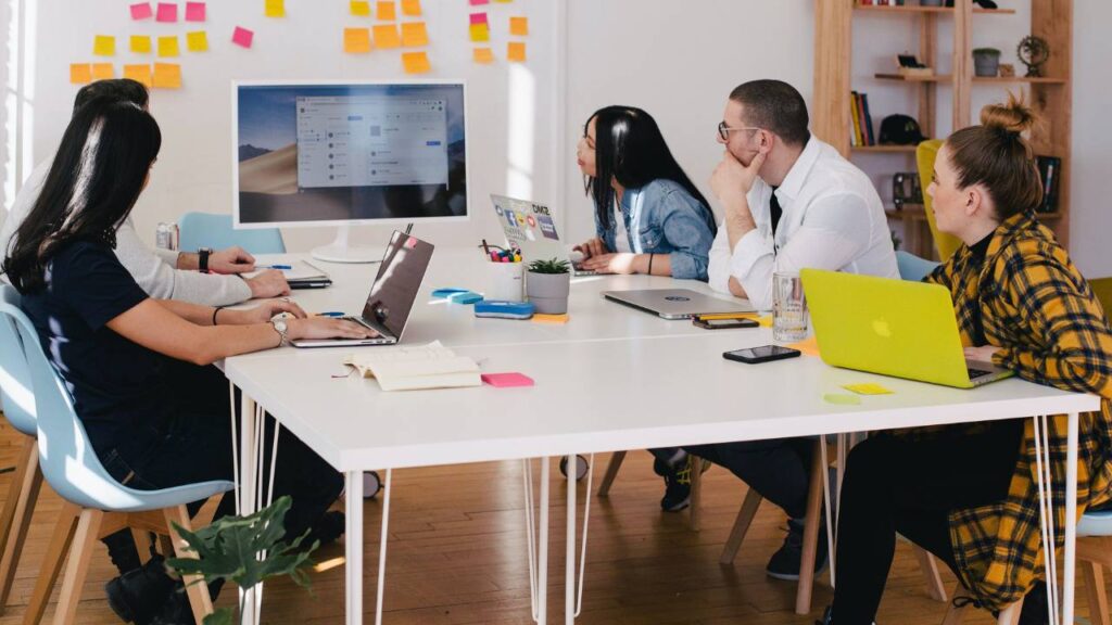 Five employees sitting and watching an important presentation together